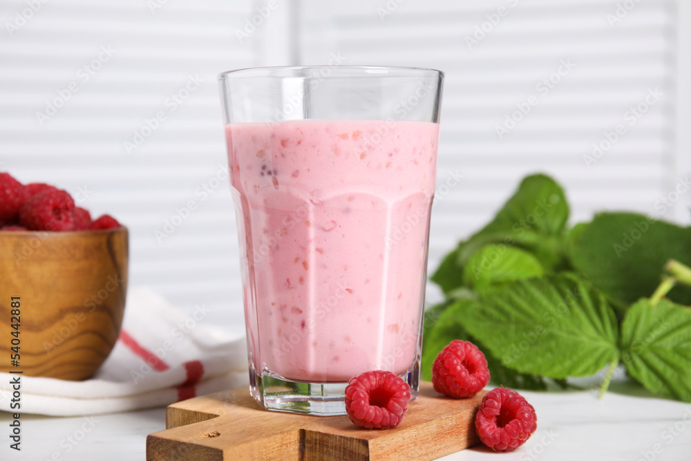 Tasty raspberry smoothie in glass on white table Tasty raspberry smoothie in glass on white table
