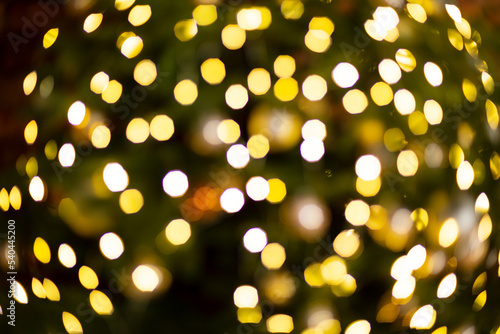Christmas  tree and festive bokeh lighting  blurred holiday background yellow and green