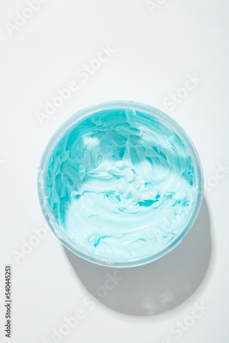 Top view of blue cream boby sutter in jar cometic products on light surface