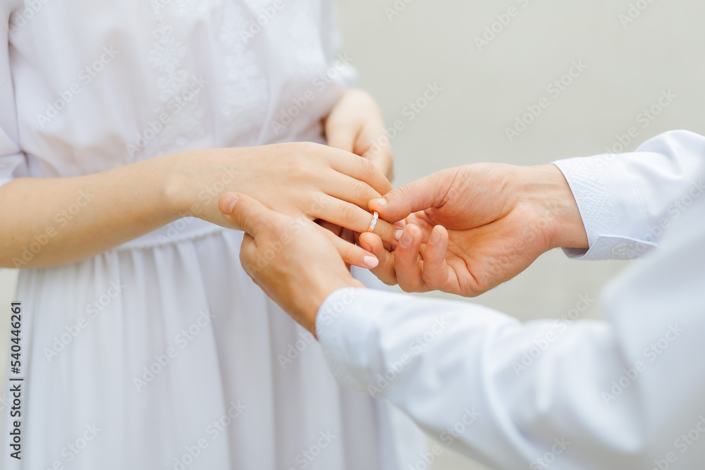 Hands of the newlyweds. A man's hand puts on a ring. wedding ceremony. Bride hands Hands of the newlyweds. A man's hand puts on a ring. wedding ceremony. Bride hands