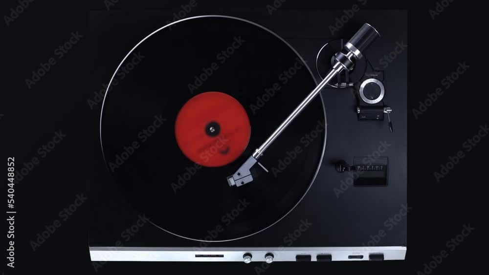Top view on black turntable with rotating LP record. Gramophone playing vinyl disc. Top view on black turntable with rotating LP record. Gramophone playing vinyl disc.