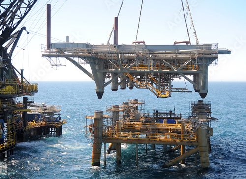 Foto workers are transported to the topside section of an offshore platform lowered o