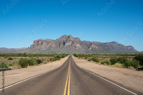 Standing on a straight road leading to the Superstition Mountains  photo
