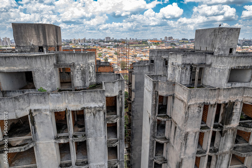 Abandoned buildings in the city of Campinas, countryside of São Paulo. Vegetation, construction debris and vehicles circulating around the residential neighborhood. © Paulo