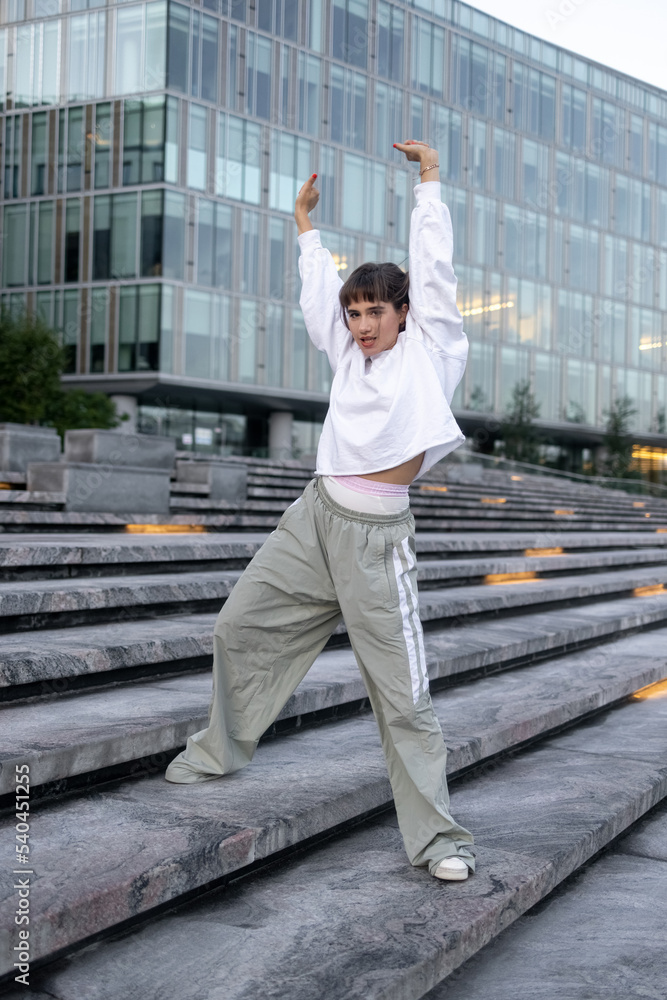 Beautiful hip hop girl dancing on the street 