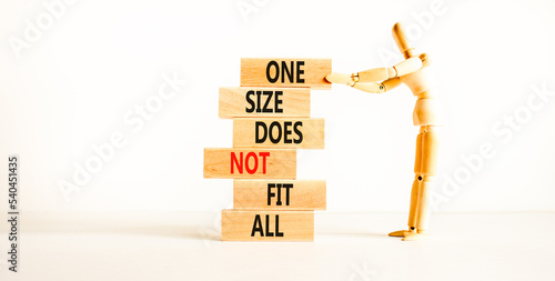 One size does not fit all symbol. Concept words One size does not fit all on wooden blocks. Businessman hand. Beautiful white background. One size does not fit all business concept. Copy space. photo