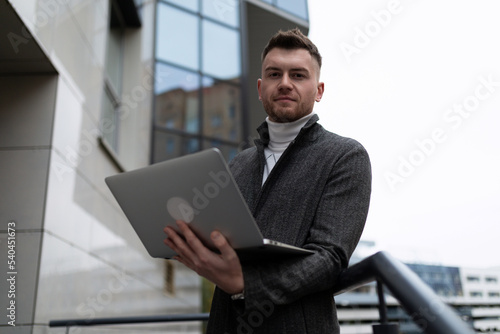 portrait of a young businessman with a laptop outside the office © Ivan Traimak