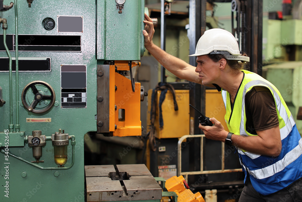 Technician engineer or worker in protective uniform standing and repairing operation or checking industry machine process with safety hardhat at heavy industry manufacturing factory Technician engineer or worker in protective uniform standing and repairing operation or checking industry machine process with safety hardhat at heavy industry manufacturing factory