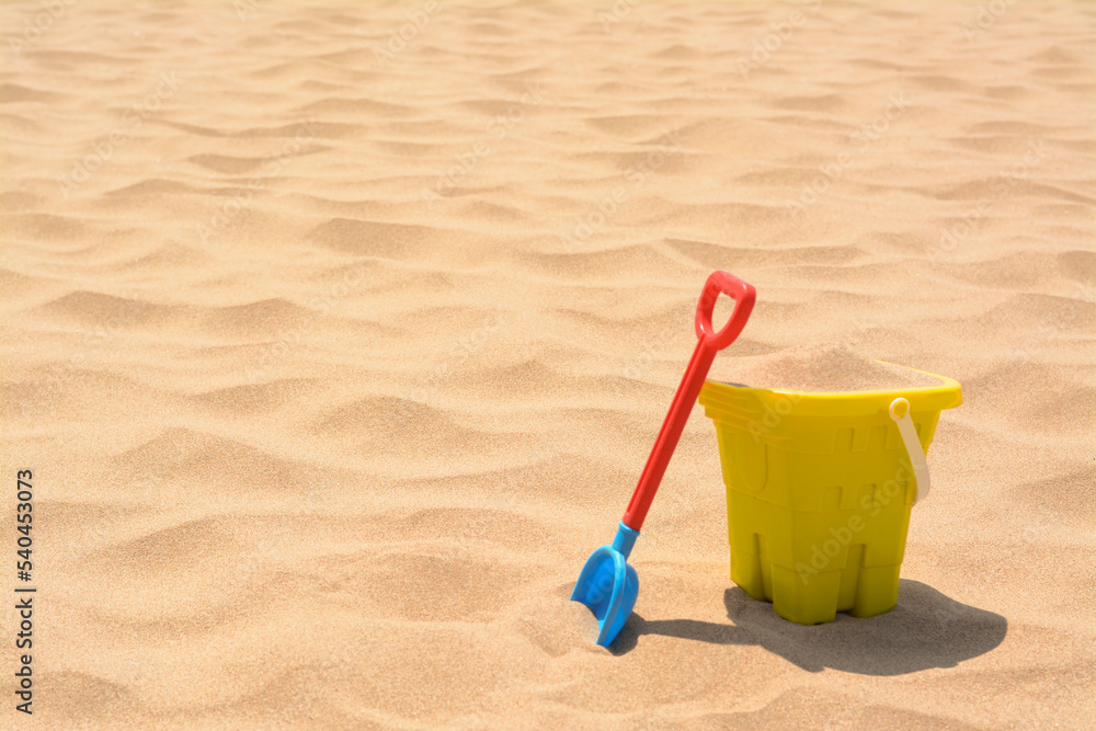 Plastic bucket and shovel on sand, space for text. Beach toys Plastic bucket and shovel on sand, space for text. Beach toys
