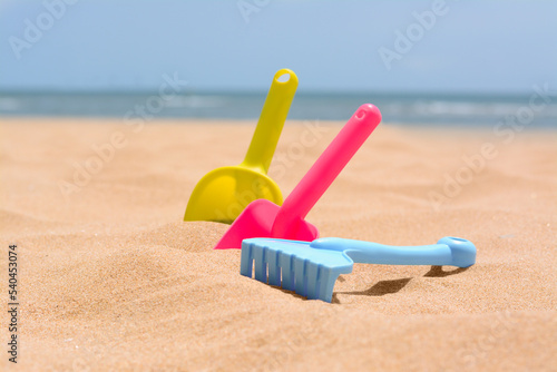 Set of colorful beach toys on sand near sea