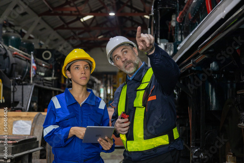 Railway engineer inspects diesel engine Report on the progress of engine parts in the factory. with safety standards 