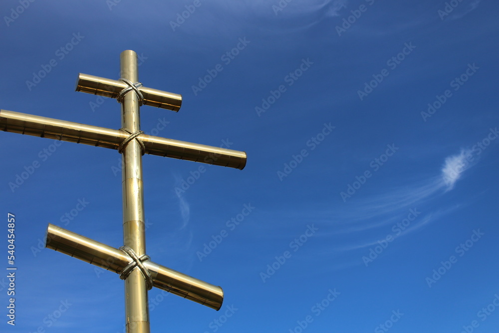 golden cross on a blue sky background golden cross on a blue sky background