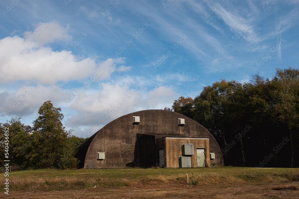 cold war bunker for military fighter jets under a blue sky in fall.