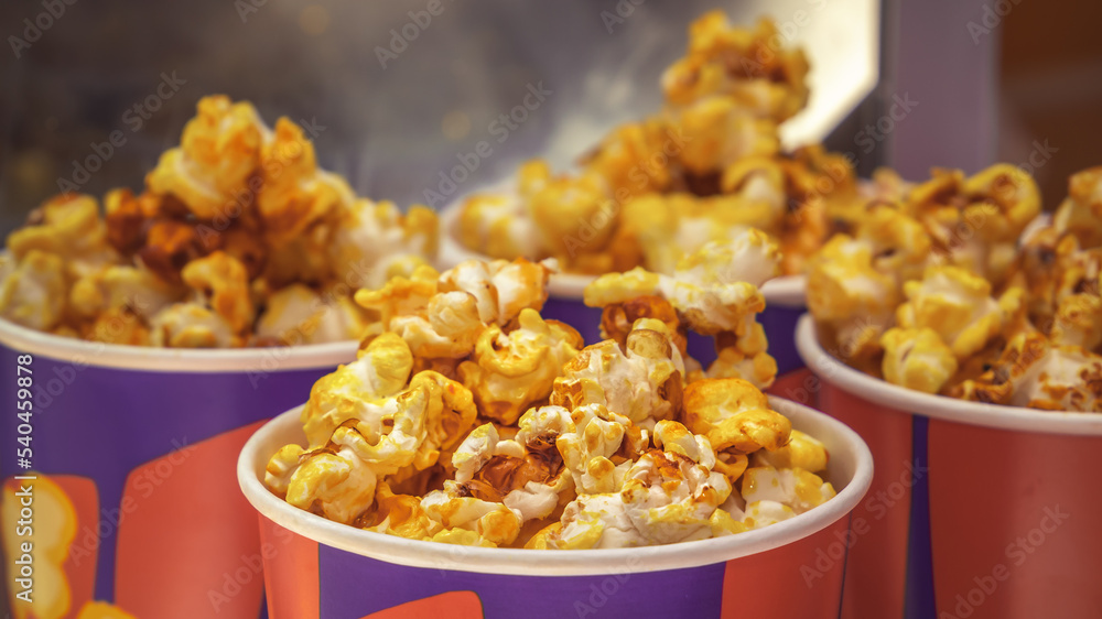 Popcorn in paper cups is served on a street stall. Close-up Popcorn in paper cups is served on a street stall. Close-up