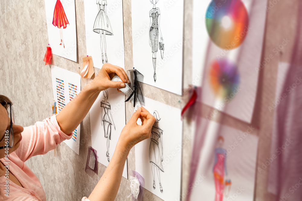Woman fashion designer is working on creating sketches of dresses ...