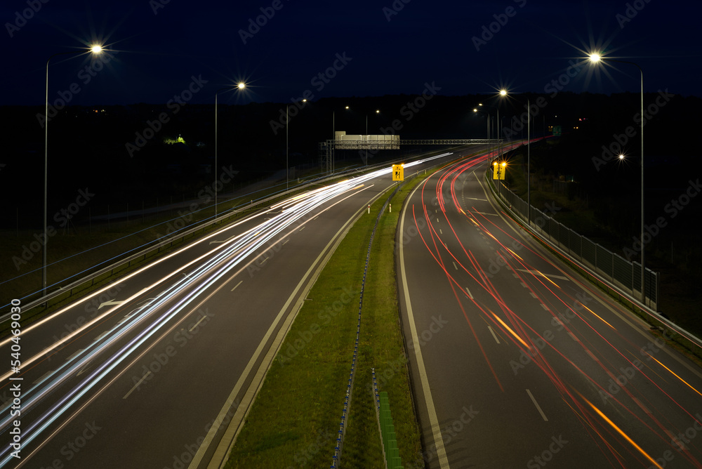 ON THE ROAD AT NIGHT - Car traffic on a modern expressway
