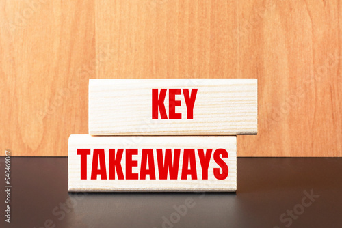 Two wooden blocks with the text KEY TAKEAWAYS on a light wooden background