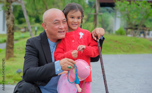 Senior man and graddaughter enjoy being together in park. photo