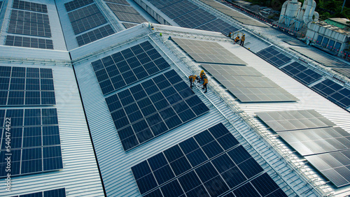 Obraz na płótnie Fly over unidentified Engineering set up a Solar cell on the roof of a large industrial factory. Solar roofs are generating renewable energy for the industry. w salonie