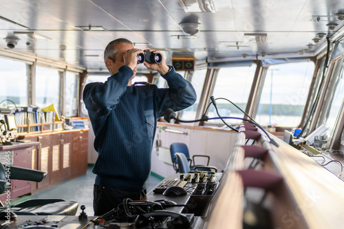 Konstfotografi Deck officer with binoculars on navigational bridge