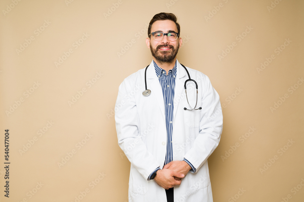 Happy male doctor with a lab coat and a stethoscope smiling Happy male doctor with a lab coat and a stethoscope smiling