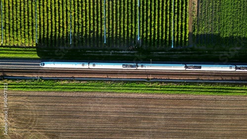 Luftaufnahme einer zweigleisigen Eisenbahn auf dem Land mit vorbeifahrendem Hochgeschwindigkeitszug