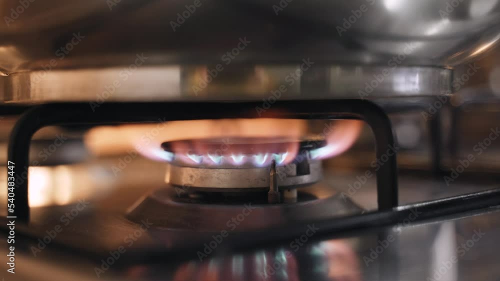 Saucepan on fire on a gas stove burner, close-up. Energy crisis and rising energy prices. Saucepan on fire on a gas stove burner, close-up. Energy crisis and rising energy prices.