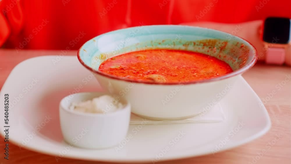 Serving thai soup on table. Unrecognizable woman eating spicy tom yam soup in restaurant. Food concept. Close up. Serving thai soup on table. Unrecognizable woman eating spicy tom yam soup in restaurant. Food concept. Close up.