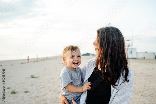Happy family. Mother and son rest on the sea. Mother and teenage son walking on the beach, they are having fun and fooling around.