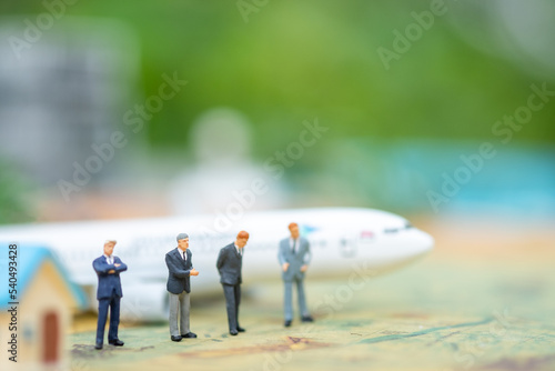 Miniature people : businessmen on airplane with copy space for text using as background saving, investment, money, financial, business analytics concept.