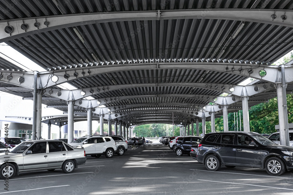 Cars parked under canopy near supermarket Cars parked under canopy near supermarket