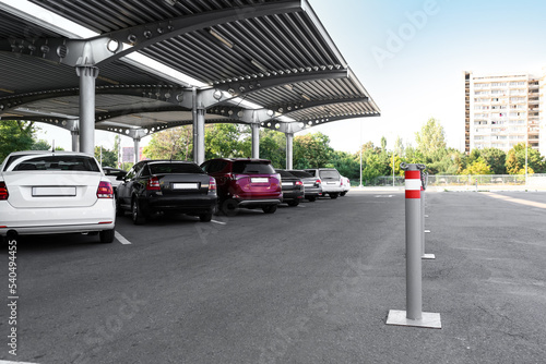 Limiters with red and white stripes on parking under canopy © Pixel-Shot