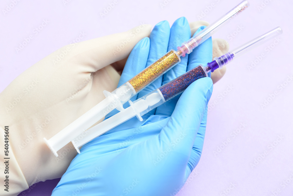 Woman in different medical gloves holding syringes on color background, closeup Woman in different medical gloves holding syringes on color background, closeup