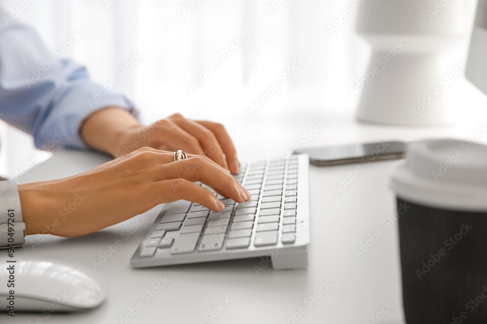 Young woman working with computer at table in office, closeup Young woman working with computer at table in office, closeup