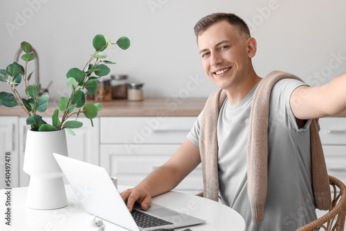 Young man with laptop takin...