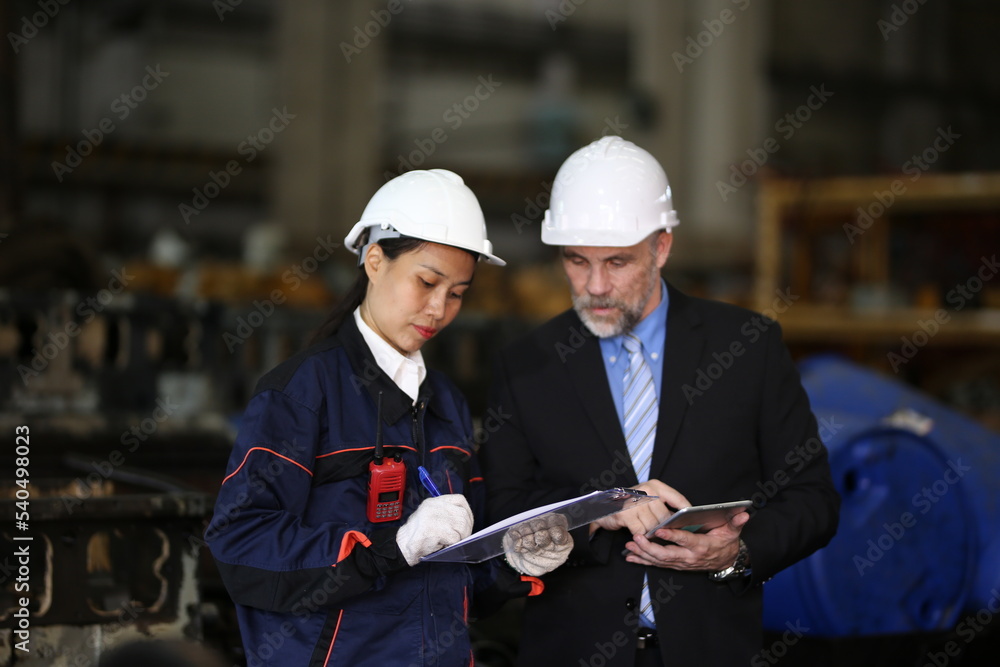 Factory manager and female engineer in factory and inspecting factory in industry plant background. Factory manager and female engineer in factory and inspecting factory in industry plant background.