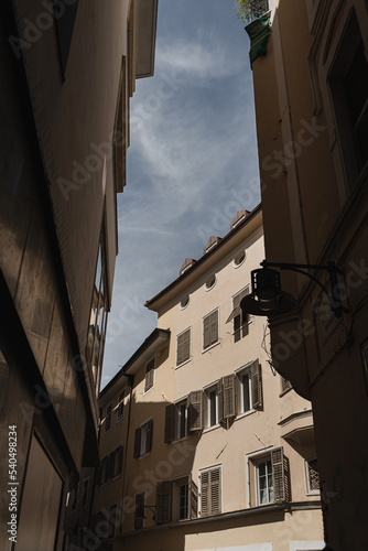Old historic Italian architecture. Traditional European old town buildings. Wooden windows, shutters and colourful pastel walls with sunlight shadows. Aesthetic summer vacation travel background