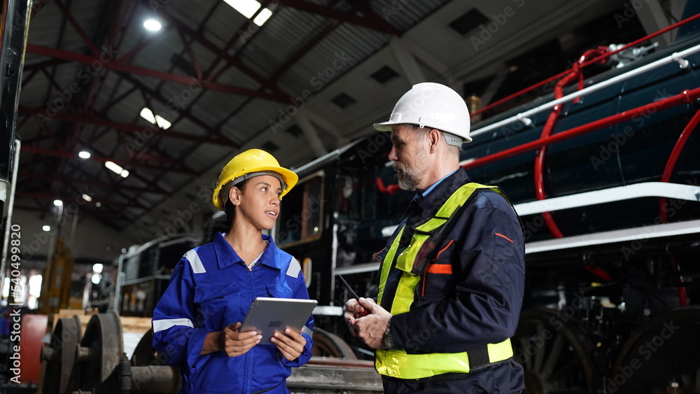 Group of apprentices with instructor at railway engineering facility. Teacher talking to apprentices at railway engineering facility Group of apprentices with instructor at railway engineering facility. Teacher talking to apprentices at railway engineering facility
