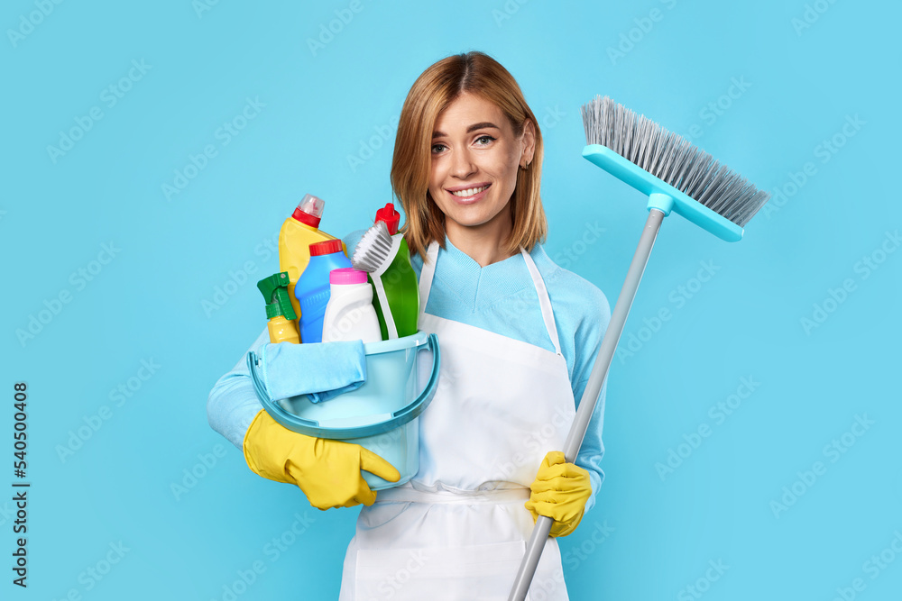 woman in gloves holding bucket of detergents and broom woman in gloves holding bucket of detergents and broom
