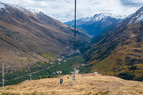 View of the mountain gorge with a single-seat cable car line for tourists, skiers and climbers. Mountains, extreme tourism. Selective focus.