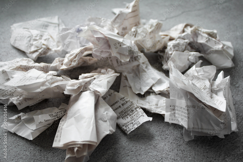 Many crumpled receipts from stores. The concept of shopping and purchases. Gray background. copy space