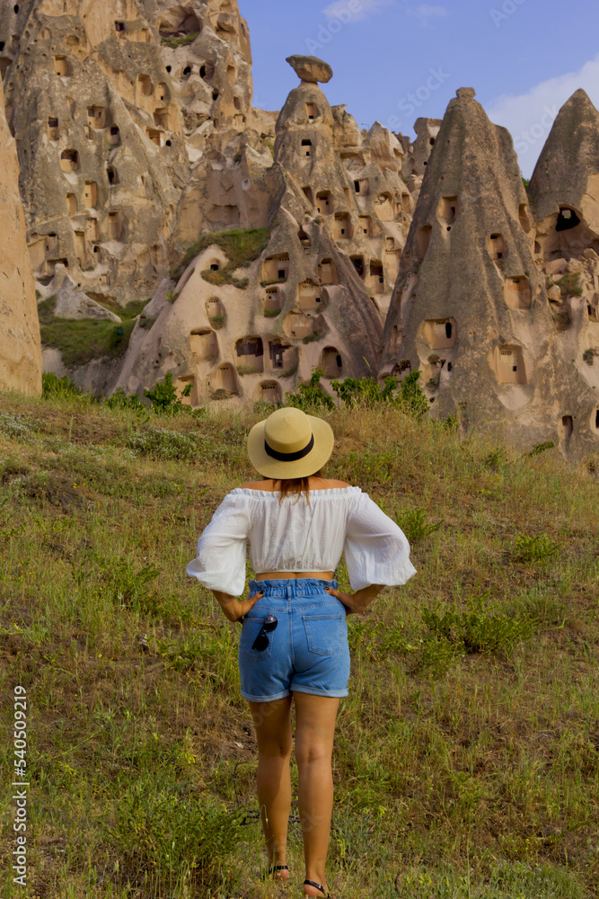 beautiful woman in a hat in uchisar castle in cappadocia, turkey	