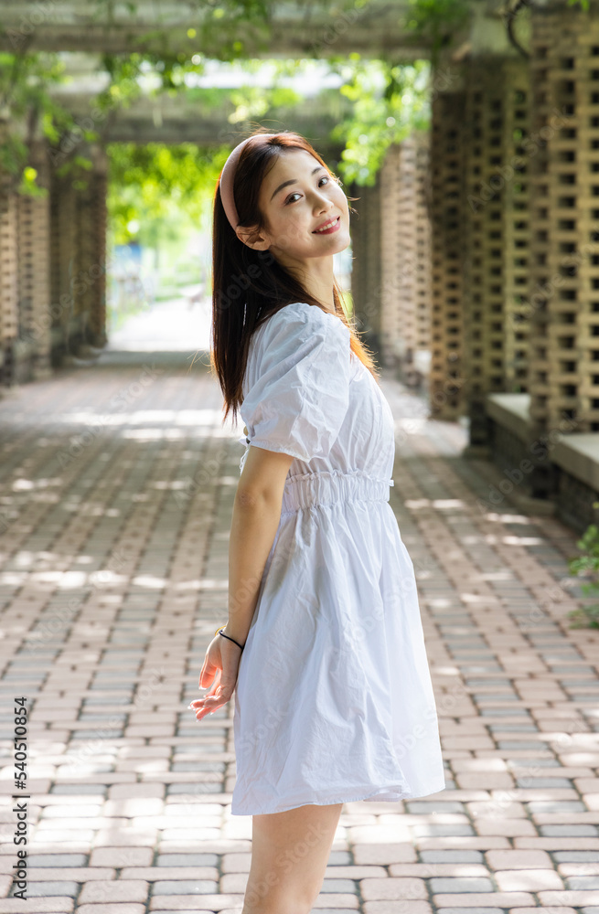 The beautiful Asian girl in the park corridor The beautiful Asian girl in the park corridor