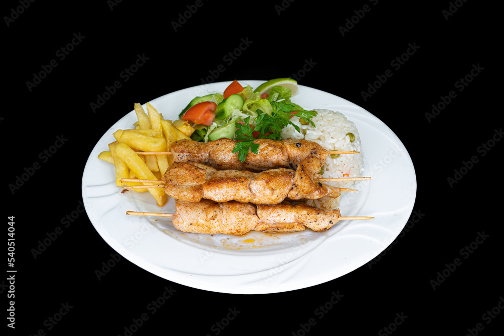 Grilled chicken skewers with rice, salad and french fries in a white plate Grilled chicken skewers with rice, salad and french fries in a white plate