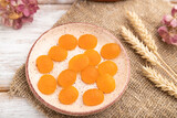 Jelly pumpkin candies on white wooden background. copy space, side view, selective focus.