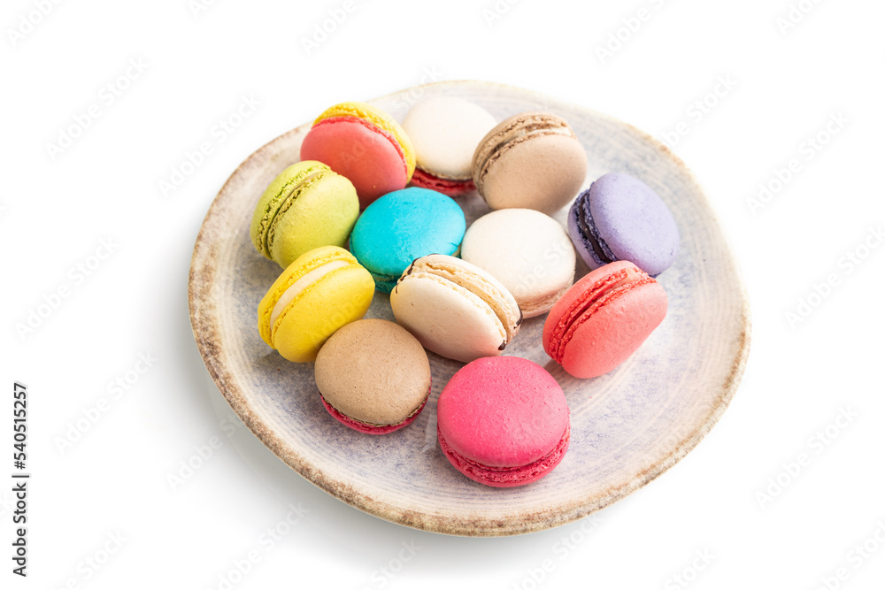 Different colors macaroons on ceramic plate isolated on white background. side view, close up. Different colors macaroons on ceramic plate isolated on white background. side view, close up.