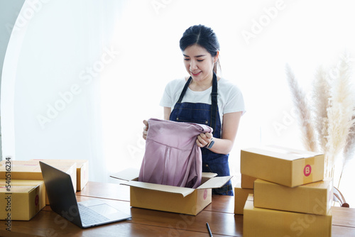 Starting small business entrepreneur of independent Asian woman smiling with cheerful success of online marketing package box items and SME delivery concept