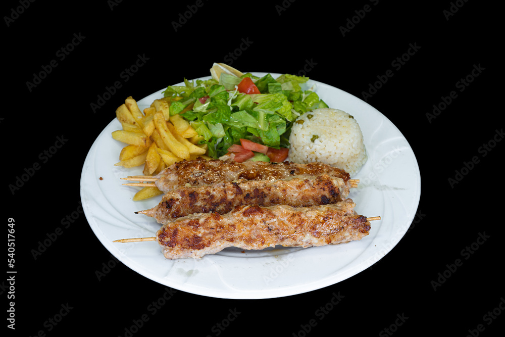 Grilled chicken Adana with rice, salad and french fries in a white plate