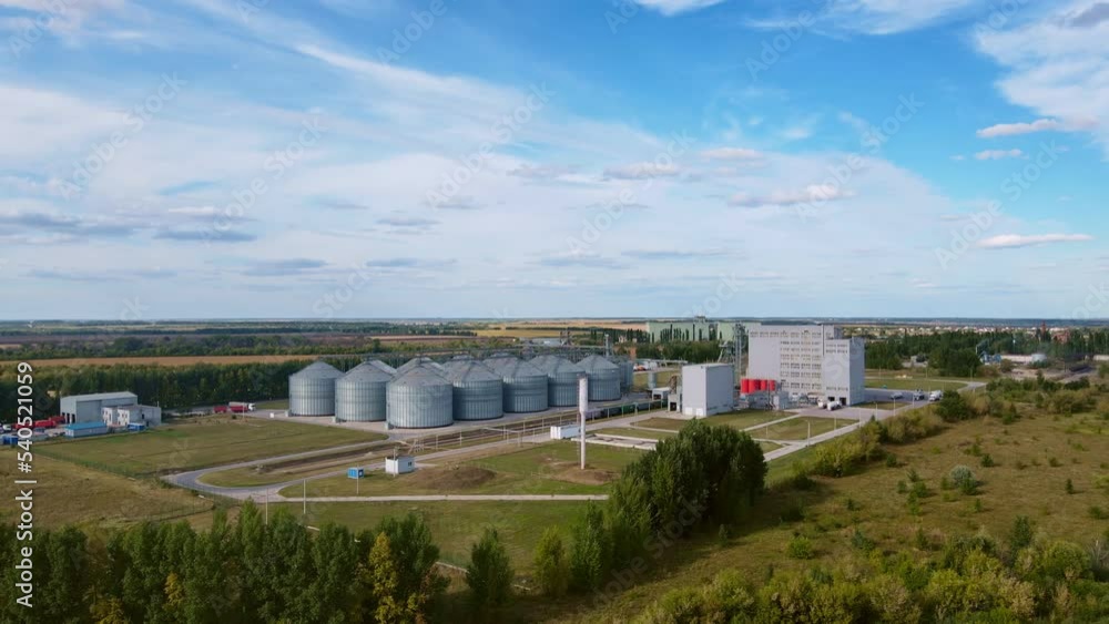 Grain elevator at modern agro processing factory in counrty side. Aerial wide footage. Grain elevator at modern agro processing factory in counrty side. Aerial wide footage.