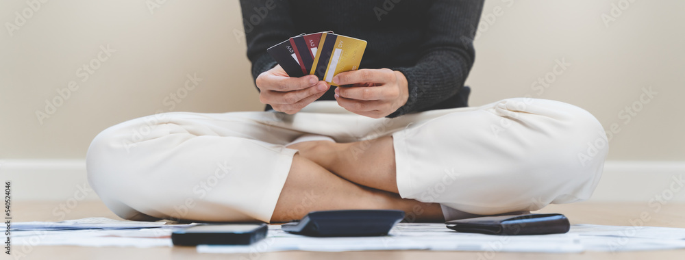 Φωτογραφία Sad Asian woman looking at many credit cards in her hand and worried about loan debt pay late